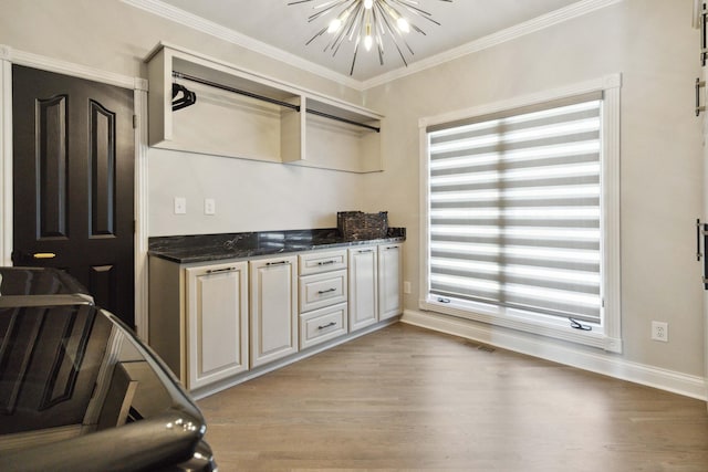 kitchen with light wood finished floors, visible vents, baseboards, ornamental molding, and a chandelier