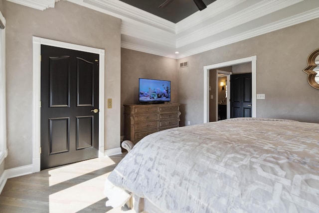 bedroom featuring ornamental molding, visible vents, baseboards, and wood finished floors