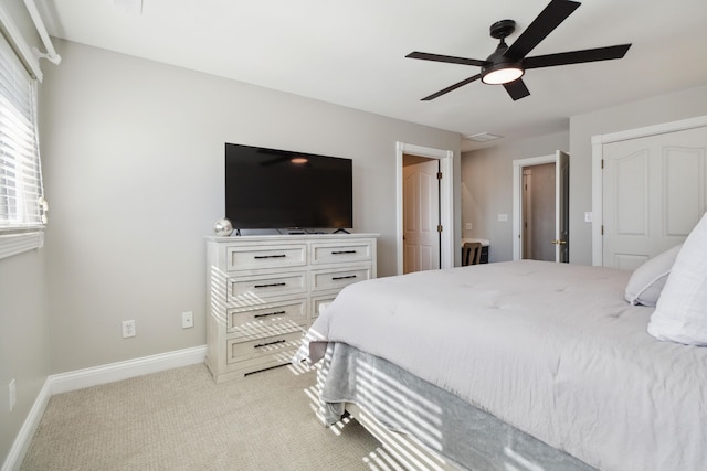 bedroom with ceiling fan, baseboards, and light colored carpet