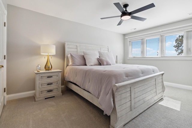 bedroom with baseboards, a ceiling fan, visible vents, and light colored carpet