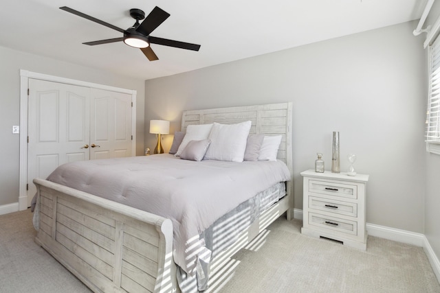 bedroom featuring light carpet, baseboards, and a closet