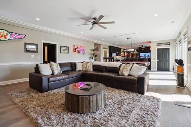 living room featuring ceiling fan, recessed lighting, wood finished floors, baseboards, and crown molding