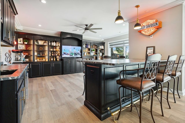 bar featuring decorative light fixtures, light wood finished floors, recessed lighting, ornamental molding, and wet bar