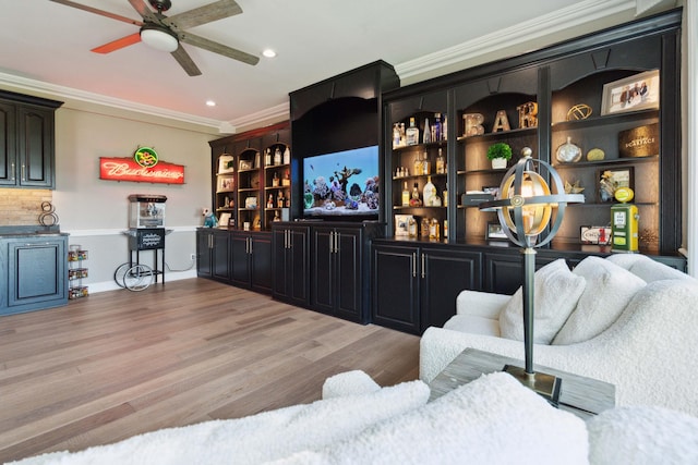 living area with ceiling fan, light wood-style floors, recessed lighting, and crown molding