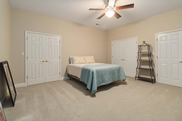 bedroom with a ceiling fan, light carpet, visible vents, and baseboards