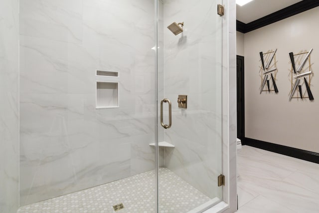 bathroom with marble finish floor, baseboards, crown molding, and a marble finish shower