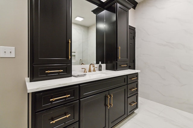 bathroom featuring a stall shower, vanity, and tile walls