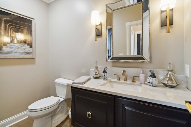 half bathroom featuring baseboards, vanity, toilet, and wood finished floors