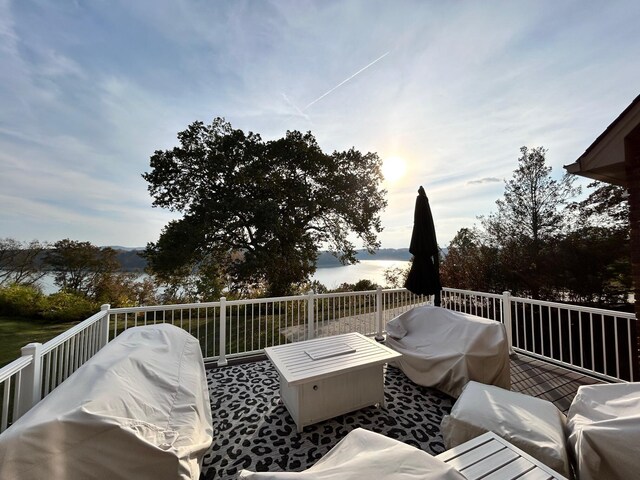 wooden deck with a water view and a grill