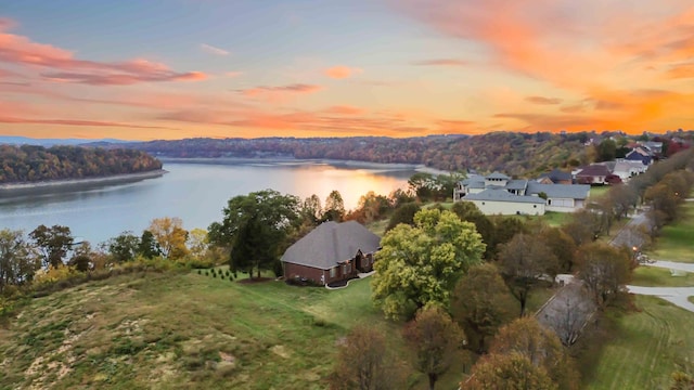 aerial view at dusk featuring a water view