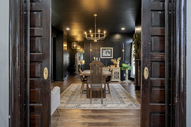 dining room featuring wood finished floors and an inviting chandelier