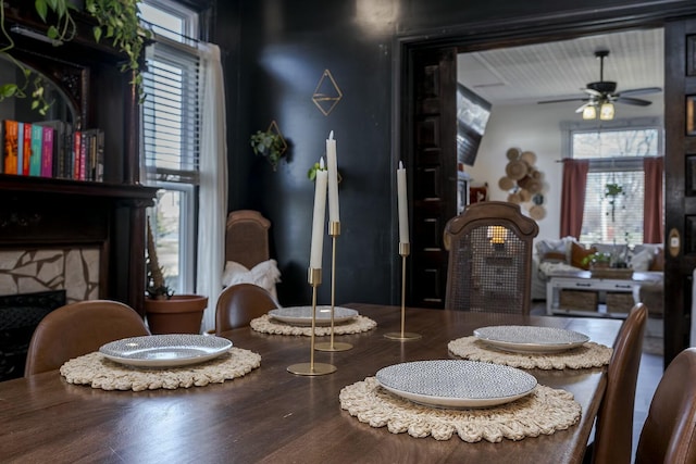 dining space with ceiling fan and a premium fireplace