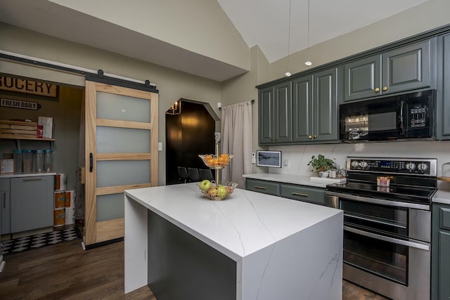 kitchen with black microwave, a barn door, vaulted ceiling, double oven range, and a center island