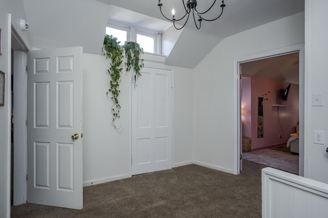 interior space with lofted ceiling, baseboards, dark colored carpet, and a notable chandelier