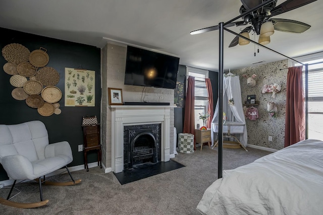 carpeted bedroom featuring multiple windows, a fireplace, a ceiling fan, and baseboards