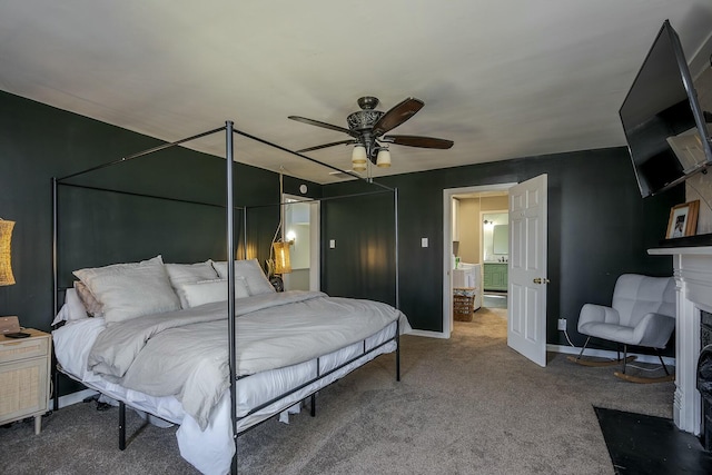 carpeted bedroom featuring a fireplace with flush hearth, baseboards, and a ceiling fan