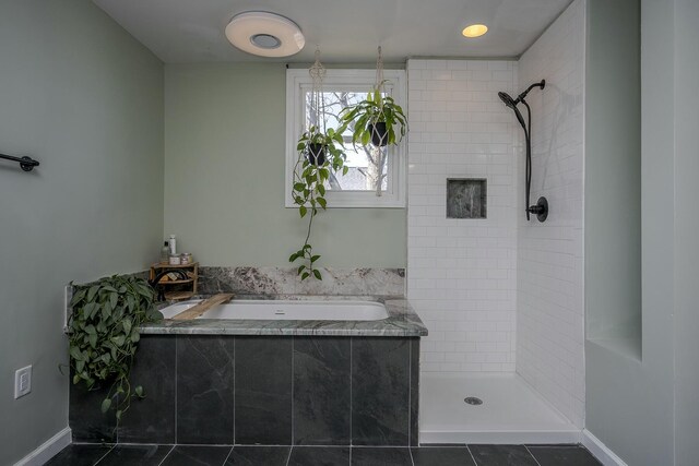 full bathroom featuring a bath, baseboards, and tiled shower