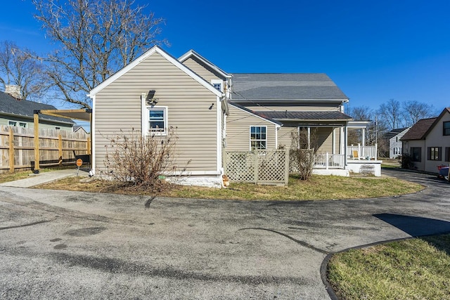 view of front of property with a porch and fence