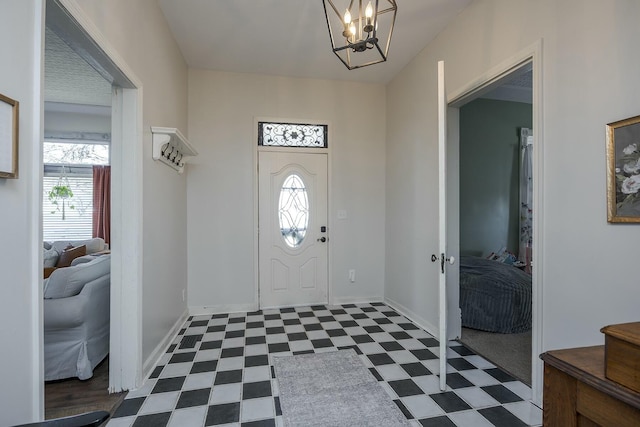 entryway featuring dark floors, plenty of natural light, an inviting chandelier, and baseboards