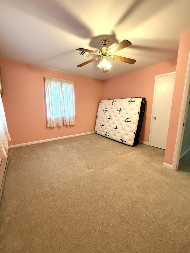 unfurnished bedroom featuring carpet, visible vents, baseboards, and ceiling fan