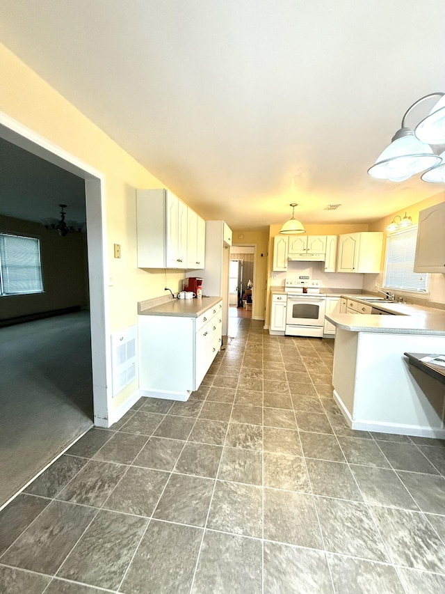 44 Pine St, Crab Orchard, KY 40419 - kitchen featuring white electric range, under cabinet range hood, light countertops, and a peninsula