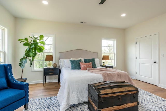 bedroom with recessed lighting, wood finished floors, visible vents, and baseboards