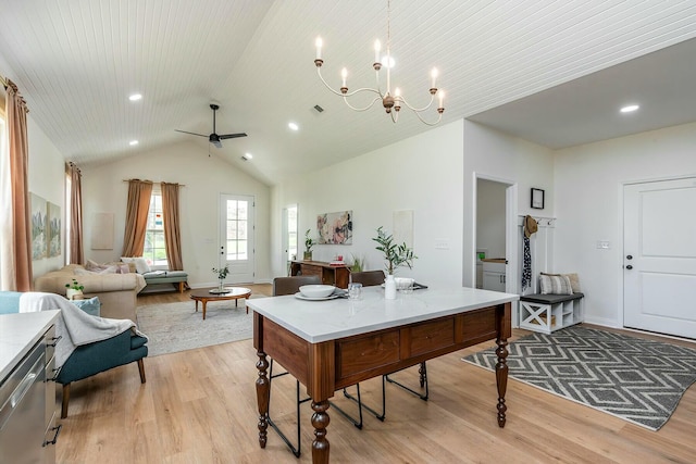 dining area with lofted ceiling, ceiling fan with notable chandelier, light wood-type flooring, and baseboards