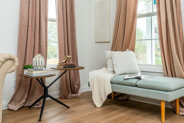 sitting room featuring baseboards and light wood finished floors