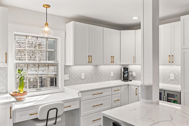 kitchen featuring tasteful backsplash, white cabinetry, and light stone countertops