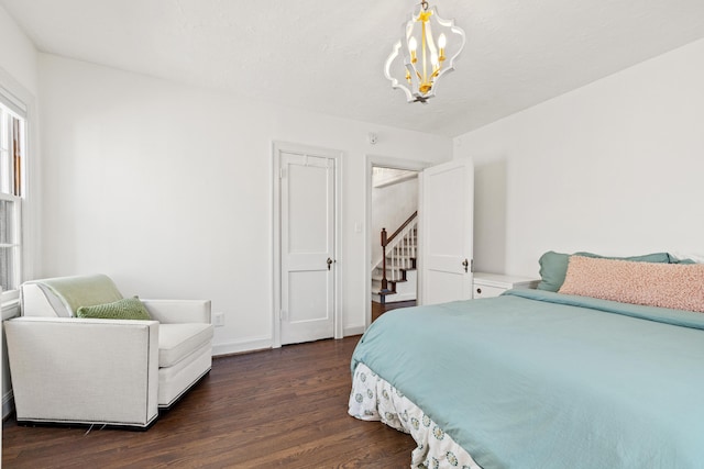 bedroom with baseboards, dark wood finished floors, and an inviting chandelier