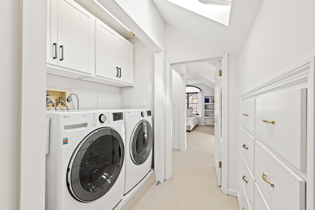 washroom featuring light carpet, cabinet space, a skylight, and washer and clothes dryer