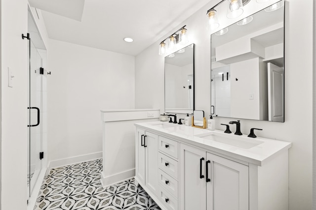 full bath featuring a stall shower, a sink, baseboards, and double vanity