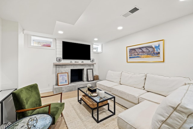 living room with recessed lighting, visible vents, a large fireplace, wood finished floors, and baseboards