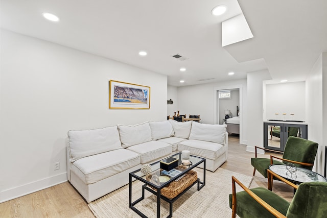 living room featuring baseboards, light wood-type flooring, and recessed lighting