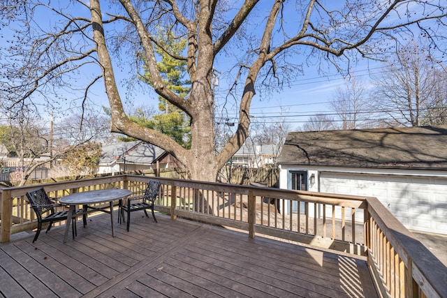 wooden deck with a garage and an outbuilding