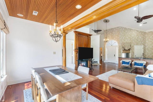 dining room with wallpapered walls, wood ceiling, ornamental molding, and ceiling fan with notable chandelier