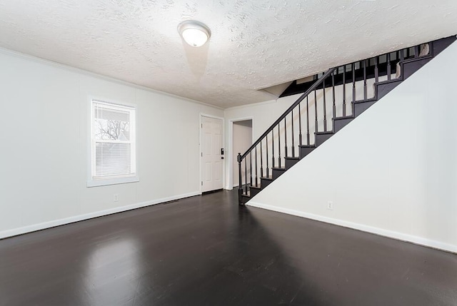 interior space with baseboards, stairway, and a textured ceiling