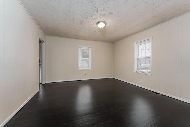 empty room featuring a textured ceiling and wood finished floors