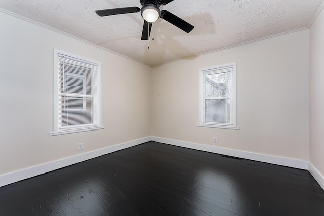 spare room with dark wood-style floors, crown molding, a textured ceiling, and baseboards