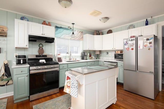 kitchen featuring dark wood-style floors, light countertops, appliances with stainless steel finishes, a sink, and under cabinet range hood