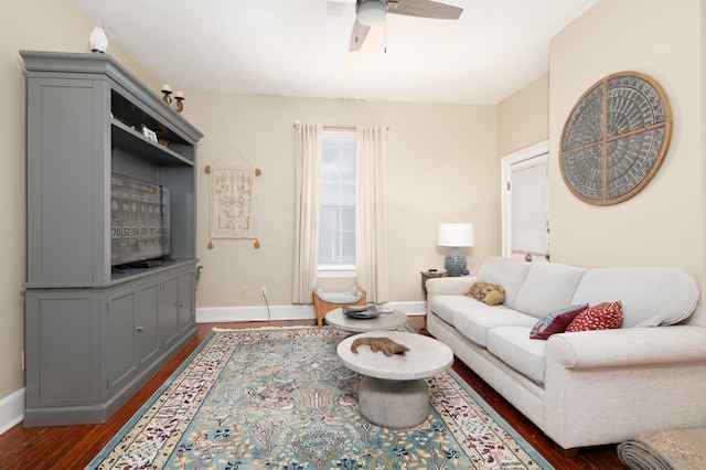 living area featuring ceiling fan, dark wood-style flooring, and baseboards