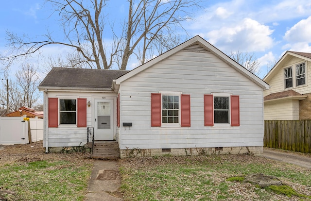 bungalow-style home with crawl space, roof with shingles, fence, and entry steps