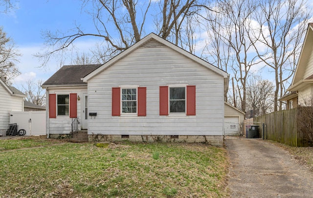 bungalow-style house with crawl space, an outdoor structure, fence, and a front yard