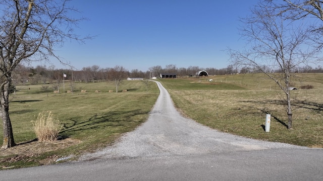 view of street featuring a rural view and gravel driveway