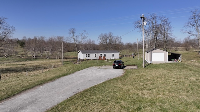 view of front of house featuring an outbuilding, a front yard, fence, dirt driveway, and a detached garage