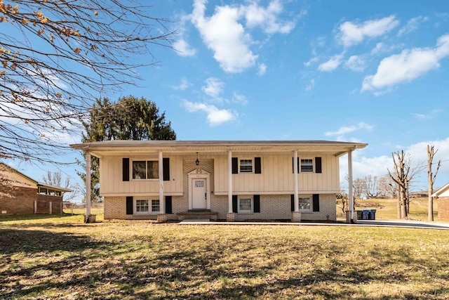 split foyer home with a front yard and brick siding