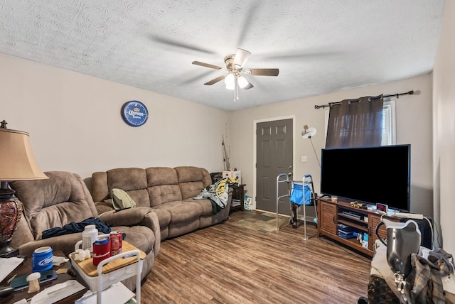 living area with a textured ceiling, wood finished floors, and a ceiling fan