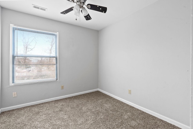 spare room with carpet floors, visible vents, ceiling fan, and baseboards