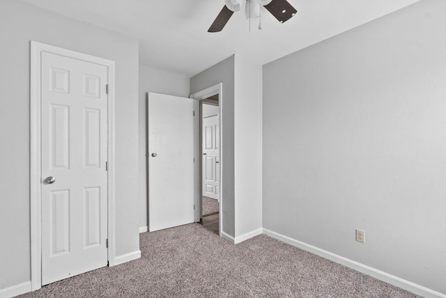 unfurnished bedroom with a ceiling fan, carpet flooring, and baseboards