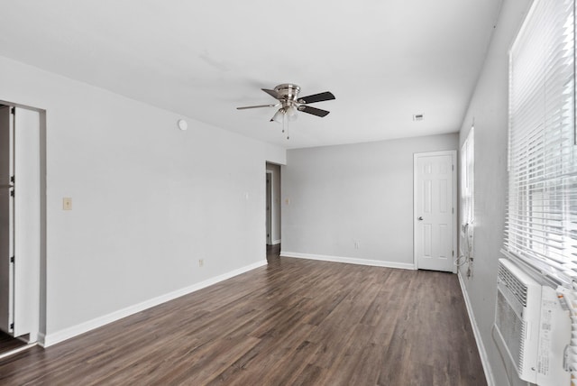 empty room with ceiling fan, baseboards, dark wood finished floors, and cooling unit